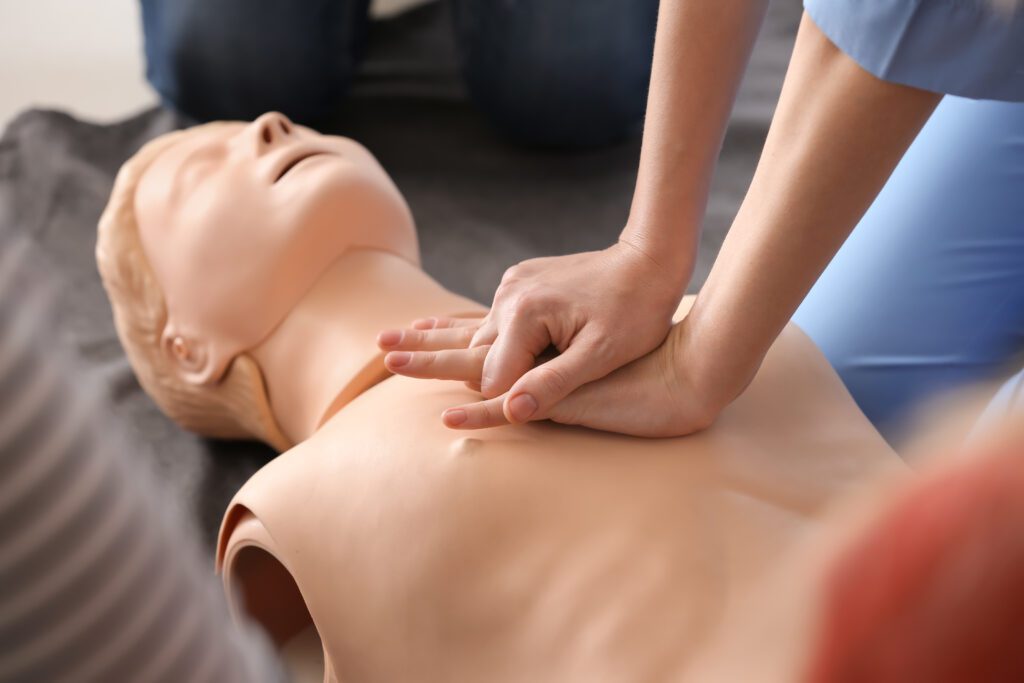 在急救培训课程中，讲师在人体模型上演示心肺复苏术