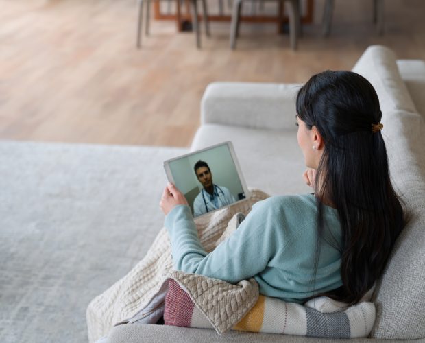 Woman at home feeling poorly and talking to her doctor on a video call